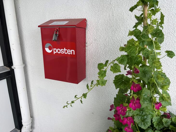 Rød postkasse på vegg